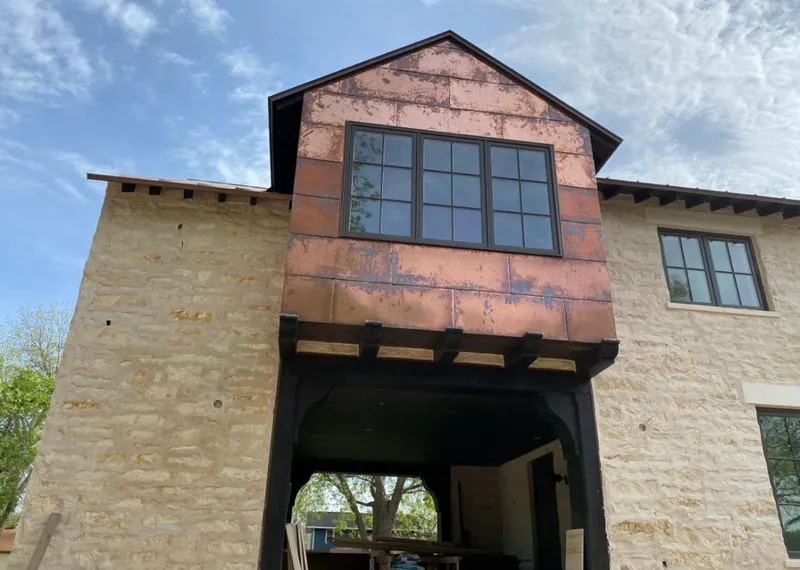 Copper metal panel facade on a stone building for Roof Repair in Ozark