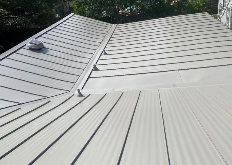 Solar attic fan installed on a metal roof for Roof Ventilation in Ozark